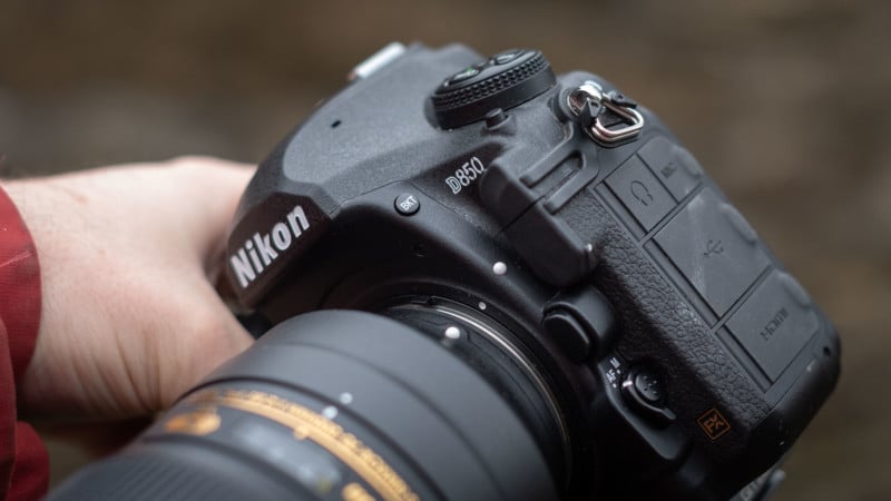 Person attaching a lens to a camera