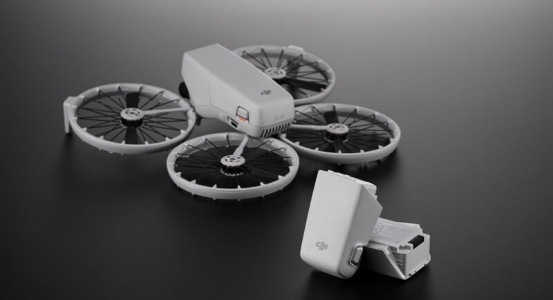 A compact, foldable drone with four circular propellers and a white body is displayed on a dark surface. Next to it is its battery pack, also in white, with the DJI logo visible.