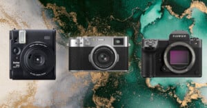 Three cameras are displayed against a green and gold abstract background: an instant camera on the left, a classic rangefinder-style camera in the center, and a mirrorless camera with no lens on the right.