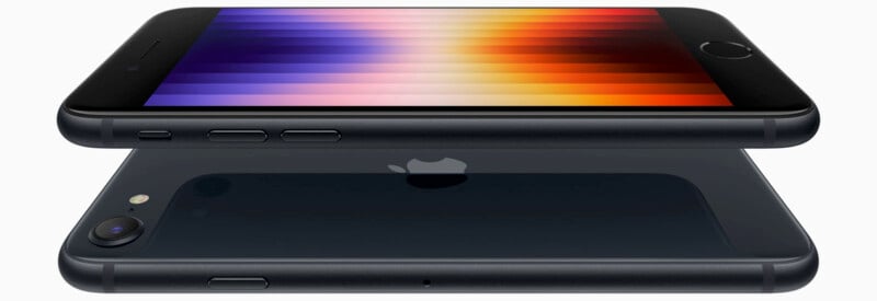 Two black smartphones are featured, one lying on top of the other. The top phone displays a vibrant screen with horizontal gradient stripes in shades of red, orange, and purple. The lower phone's back shows a camera and the Apple logo.