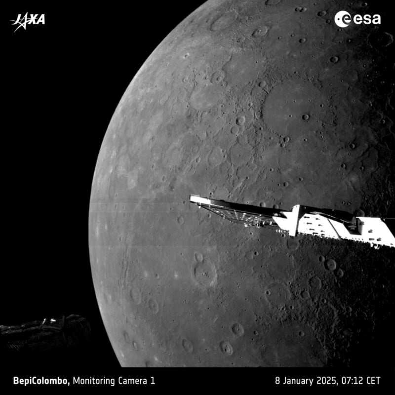 A black and white image of Mercury's cratered surface with a part of the BepiColombo spacecraft visible. The photo is credited to JAXA and ESA, taken on January 8, 2025, at 07:12 CET.