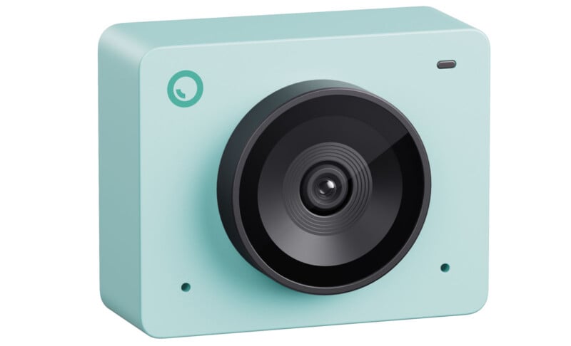 A small, mint green action camera with a wide-angle lens on the front. The camera has a circular lens and a minimalist design with rounded edges, featuring a small logo in the top left corner and an indicator light in the top right corner.