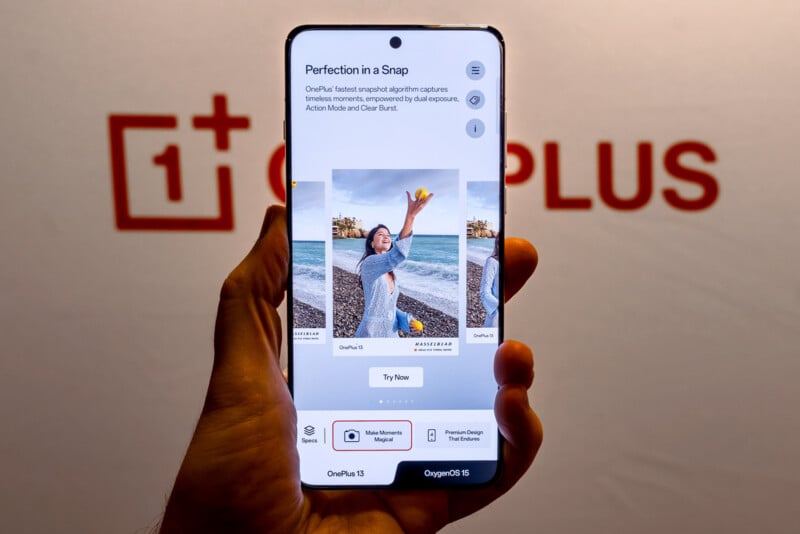 A hand holds a smartphone displaying a camera app interface with photos of a person by the sea. The screen shows text about camera features. The background features a blurred OnePlus logo.