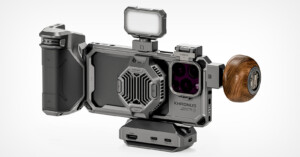 A futuristic smartphone camera rig featuring a metallic frame, wooden grip, external lens attachments, LED light, and various ports. Designed for professional photography and videography, it has a robust and sleek design.