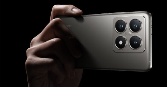 Close-up image of a hand holding a sleek, modern smartphone with a quad-camera setup on the back. The metal finish of the phone is highlighted against a black background, showcasing the sophisticated design and prominent camera lenses.